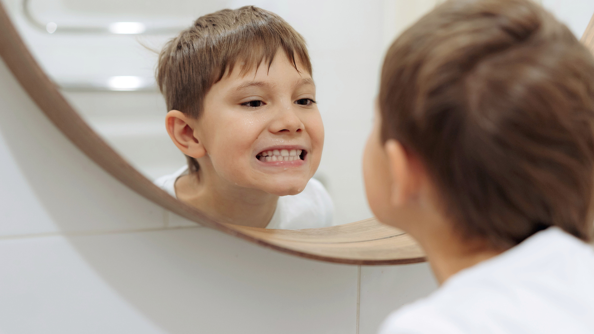 bambino controlla allo specchio di non avere i denti gialli